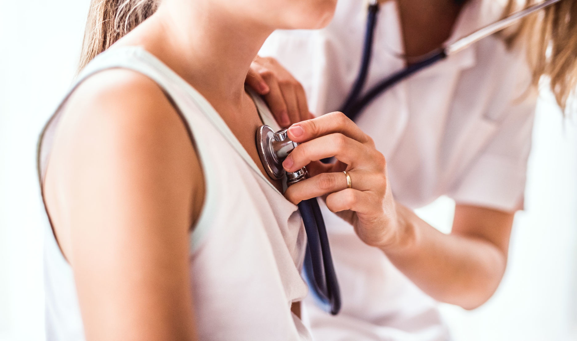 Young female doctor examining a small girl in her office.